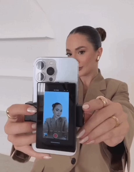 Load video: In this video, a sophisticated creator with a clean, elegant look demonstrates how she uses the GlamSnap™ Mirror to capture her content with ease. Framed in soft motion, she confidently vlogs her moment using the rear camera — made effortless with the mirrored screen attached to her phone. The video captures her graceful movements and natural glow as she engages with the camera. With one smooth motion, she gently detaches the GlamSnap™ device, showcasing its lightweight, portable design. The vibe is polished, feminine, and subtly powerful — a perfect blend of beauty and tech in motion.